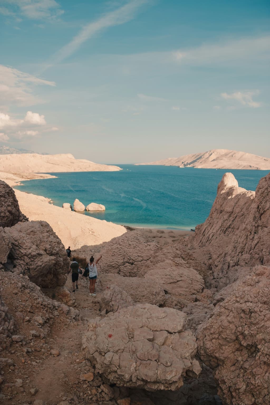 Pale rocky coast descending toward blue Adriatic water on Pag